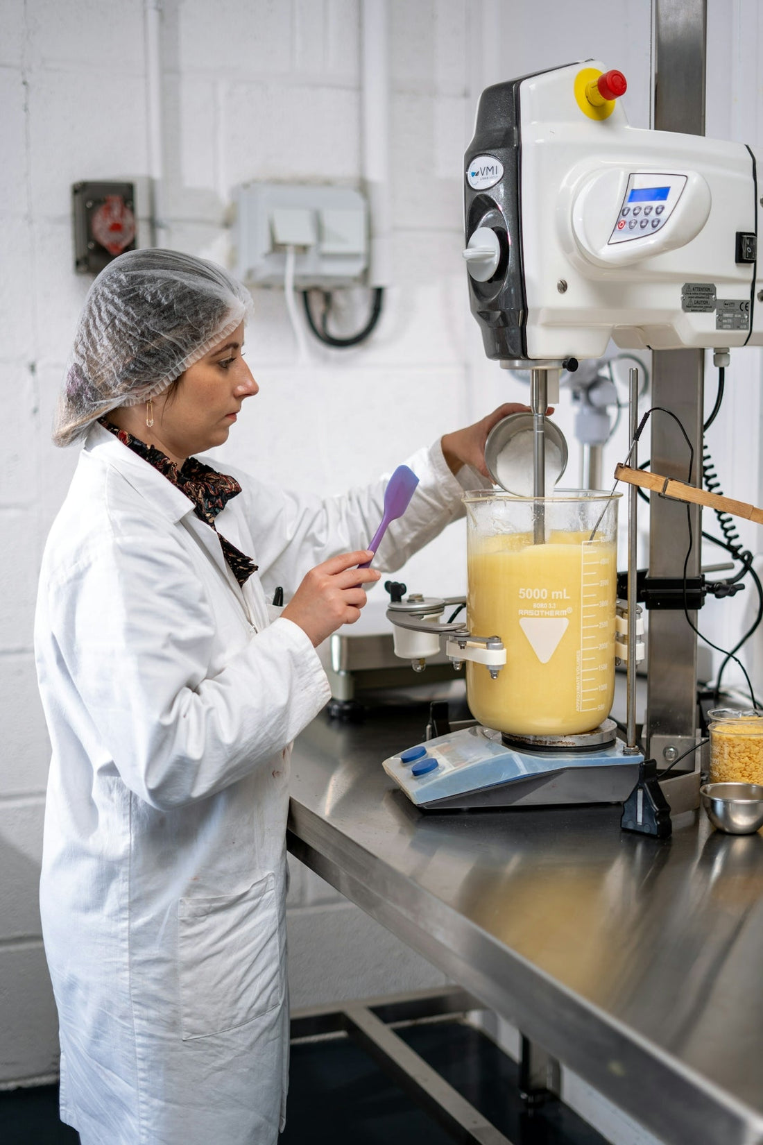 a man in a white coat working in a lab