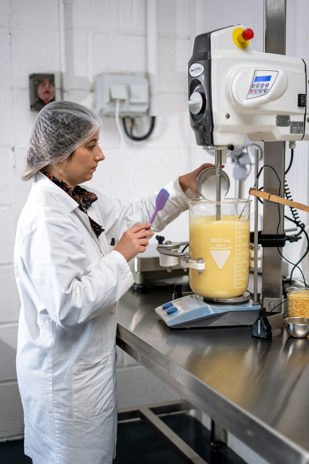 a man in a white coat working in a lab
